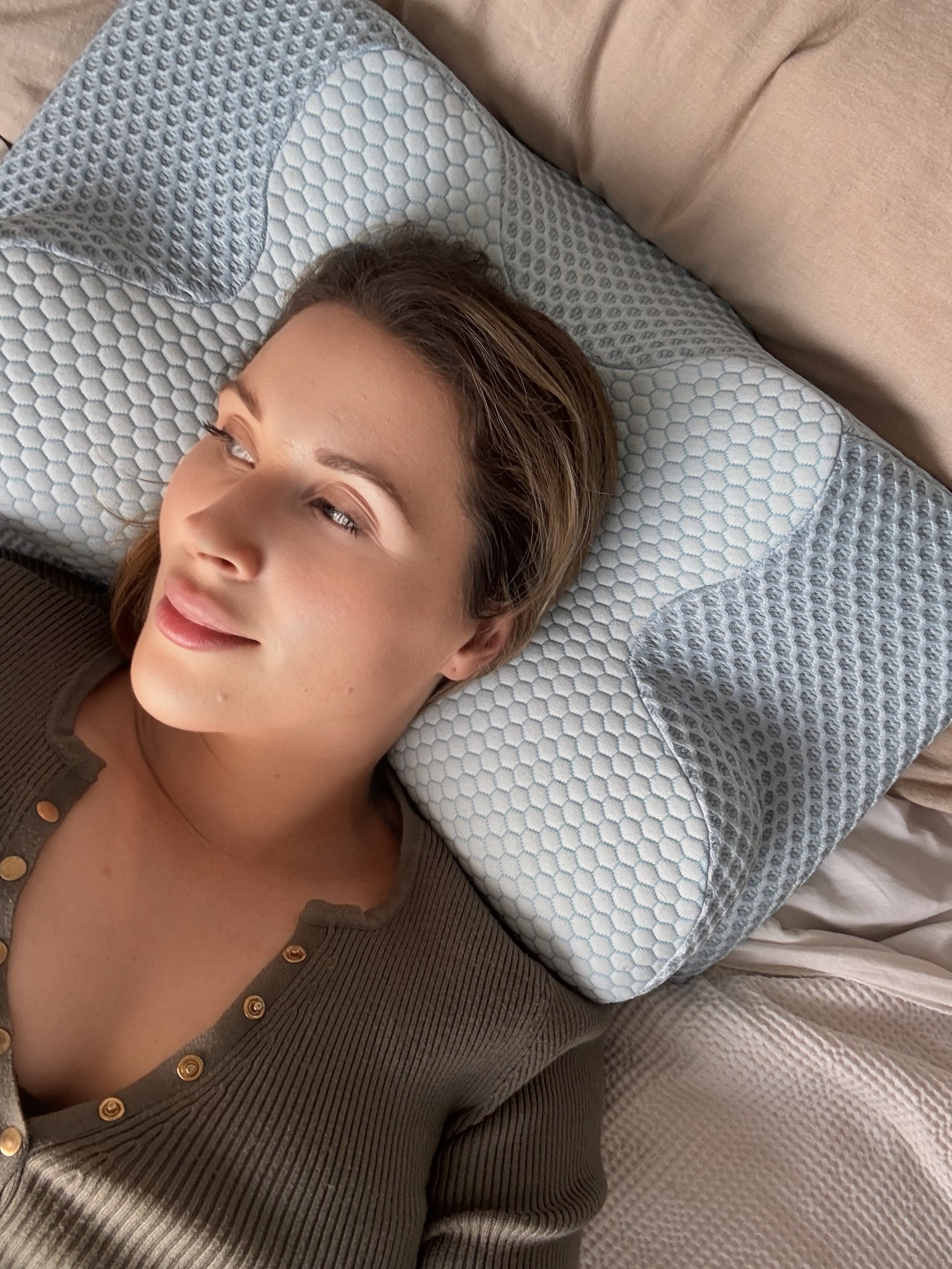 Woman sleeping on orthopaedic memory foam neck pillow for pain relief
